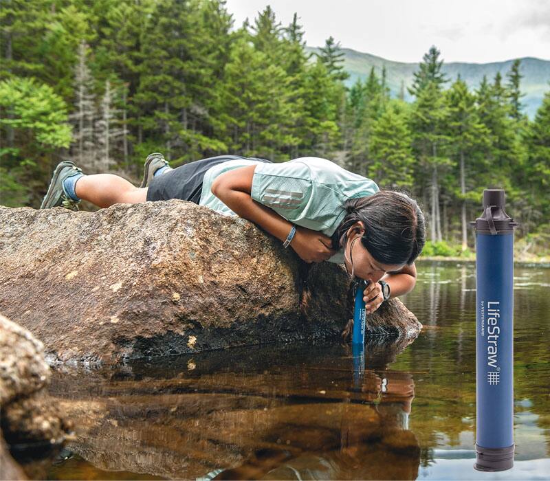 person drinking from a lake