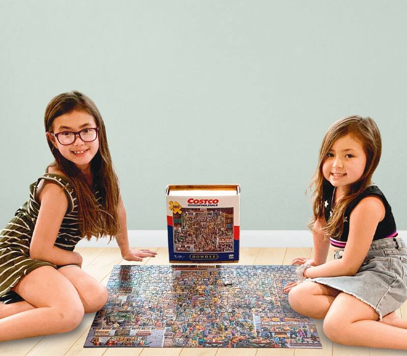 2 kids sitting on the floor with a puzzle