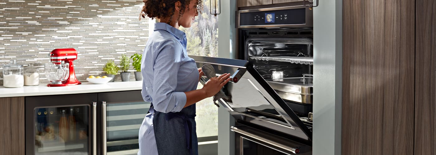 woman using a stacking KitchenAid washer and dryer combo