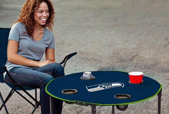 A woman sits in a folding chair at a tailgating event.