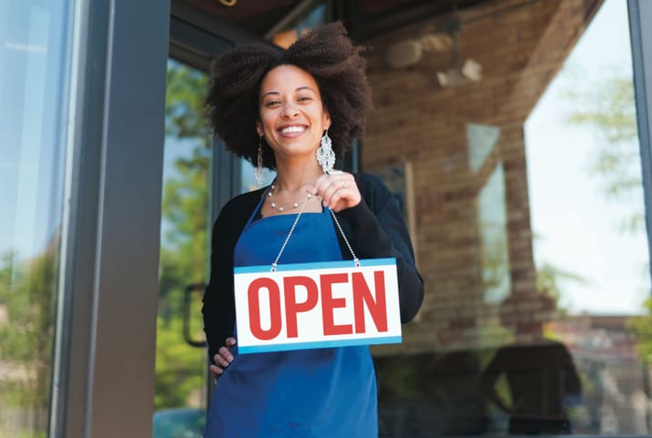 Woman holding a store open sign